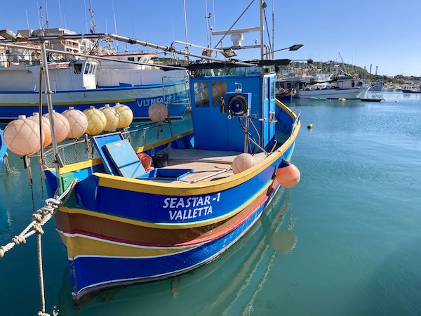 Colourful painted traditional Maltese fishing boat in Marsaxlokk Harbour