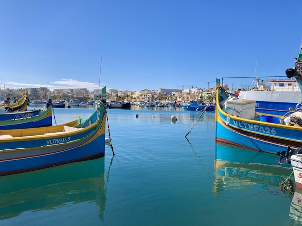 Colourful painted traditional Maltese fishing boats in Marsaxlokk Harbour