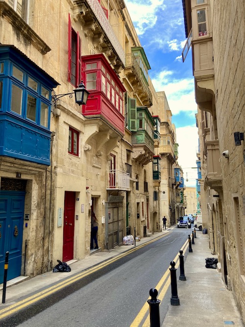 Limestone street of houses with colourful wooden balconies